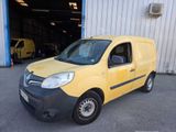 the small yellow van is parked in front of a building