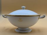 a white bowl with a gold rim on a table