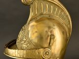 a gold helmet on a stand against a black background