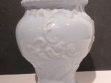 a white vase that is sitting on a table