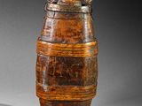 an old wooden barrel with a handle sitting on a table
