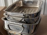 several metal pans are stacked on top of a red table