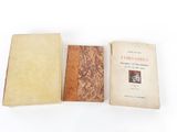 deux vieux livres posés l'un sur l'autre sur une surface blanche