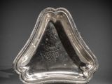 une assiette en argent ornée d'un motif sur le bord