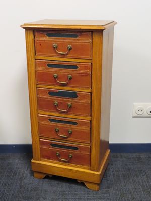 une petite commode en bois dans un coin de la pièce