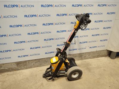 a close up of a small machine with wheels on the ground