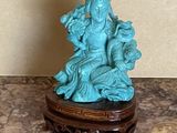 une petite statue représentant une femme assise sur une table