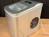 a small ice maker sitting on a wooden table