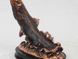 a close up of a statue of a fish on a stand