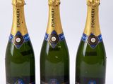 trois bouteilles de champagne sont alignées sur une surface blanche