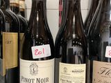 plusieurs bouteilles de vin sont alignées sur une étagère dans un magasin