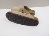 pair of tan sued shoes with black soles on a white surface