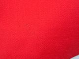 close up of a hand holding a red heart shaped pillow