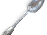 a silver spoon with a spoon handle on a white surface