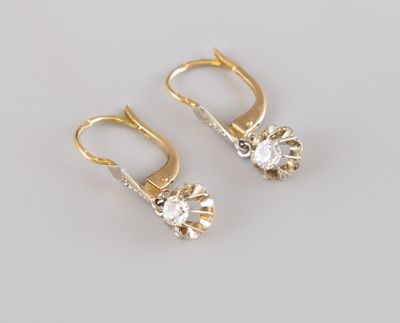 une paire de boucles d'oreilles en or et diamants sur fond blanc