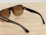 sunglasses on a wooden table with a white wall in the background