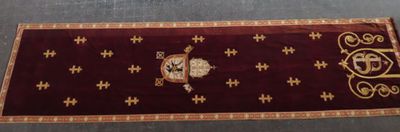a red rug with a gold cross on it