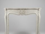 un encadrement de cheminée en marbre blanc orné d'un motif décoratif sur le dessus