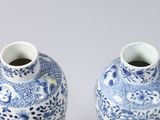 pair of blue and white vases sitting on top of a table