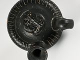 a black vase that is sitting on a white surface