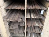 many different types of steel bars stacked on a shelf