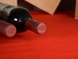 two bottles of wine sitting on a red table