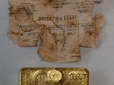 un vieux bout de papier avec un lingot d'or à côté