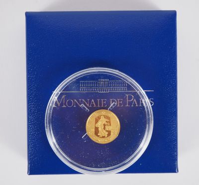 une pièce d'or dans une boîte bleue sur fond blanc