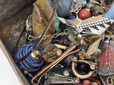a metal container filled with assorted jewelry and accessories
