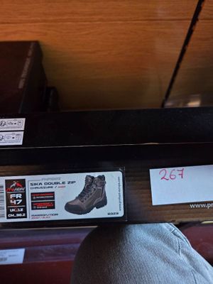 a person that is holding a pair of shoes on a shelf