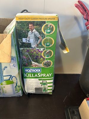 boxes of gardening supplies sit on a table next to scissors and a watering hose