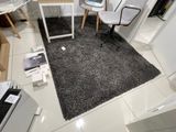 une pièce avec un bureau, une chaise, un ordinateur portable et d'autres objets posés par terre