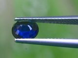 un gros plan sur une pince tenant un diamant bleu