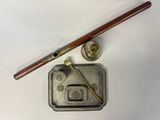 a metal tin with a wooden handle next to a pipe