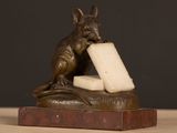 a statue of a mouse sitting on a piece of cheese