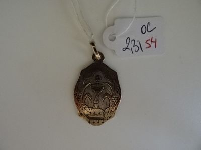 une médaille d'argent posée sur une table blanche, avec une étiquette indiquant son prix