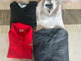 four polo shirts laid out on the floor next to each other