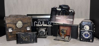 a lot of old cameras sitting on a table