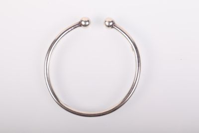 gros plan d'un bracelet en argent sur une surface blanche