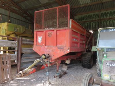 a tractor and a tractor trailer in a barn