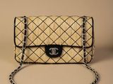 pochette tissée beige et noire avec une bandoulière en chaîne