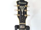 the head of an electric guitar with a sticker on it ' s neck