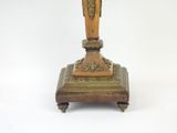a small wooden clock on a stand on a white surface
