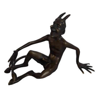 bronze statue of a man sitting on the ground with his legs crossed