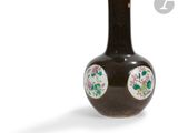 un vase marron orné de fleurs sur fond blanc