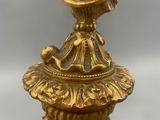 gold plated candle holder with a bird on top of it