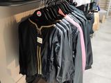 a lot of clothes hanging on a rack in a store