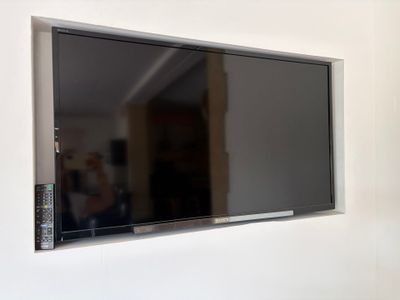 un téléviseur à écran plat fixé au mur d'un salon