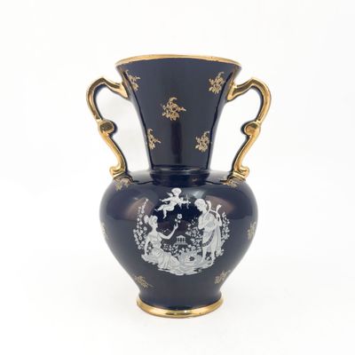 un vase bleu avec une anse dorée sur fond blanc