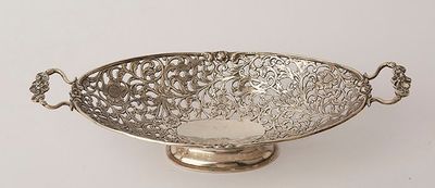 an antique silver plated bowl with handles on a stand